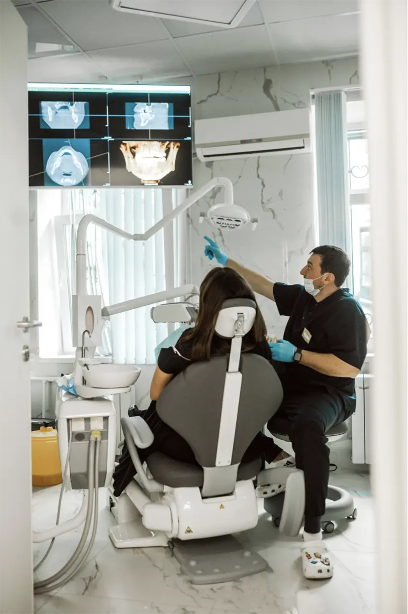 Врач показывает пациенту результаты диагностики – КТ челюсти